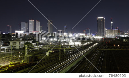JR and Aonami Line tracks seen from the Golden Overpass in Nagoya City, train light trails, night view of skyscrapers around Nagoya Station 76480603