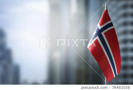 A small flag of Norway on the background of a blurred background 76481038