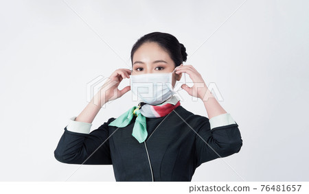 Cabin crew or air hostess with face mask in Covid 19 pandemic. Flight attendant wear medical mask to prevent coronavirus infection. New normal lifestyle in airline business. Pretty stewardess woman. 76481657