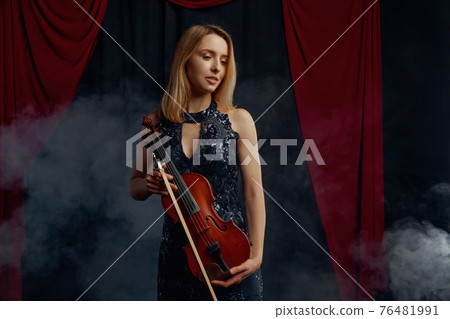Female violonist holds bow and violin 76481991
