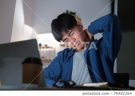 Young man overtime work and feel shoulder and neck pain at home Young man overtime work and feel shoulder and neck pain at home 76482264