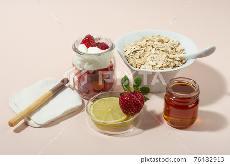 Homemade strawberry face mask ingredients: strawberry, yoghurt, honey, lemon, oatmeal. 76482913