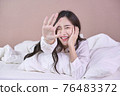 Funny and joyful Asian woman smile on bed. Close up cute girl 76483372