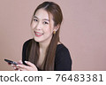 Close up of beautiful Asian woman use phone and smile 76483381