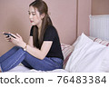Attractive Asian woman play game on bed at home 76483384