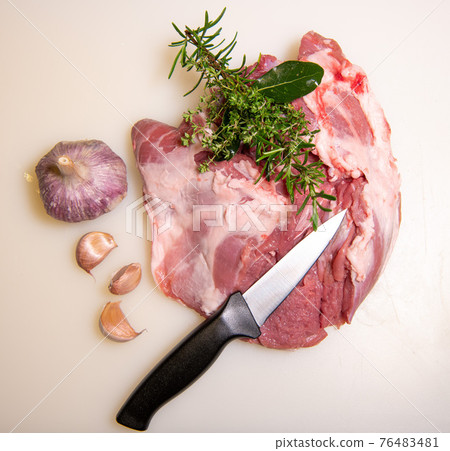Boning a shoulder of lamb leg meat on a wooden tray, white background, Top view Boning a shoulder of lamb leg meat on a wooden tray, white background, Top view 76483481