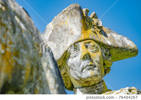Very old statue of Prussian King Frederick the Great covered with moss and lichen, Potsdam, Germany 76484267