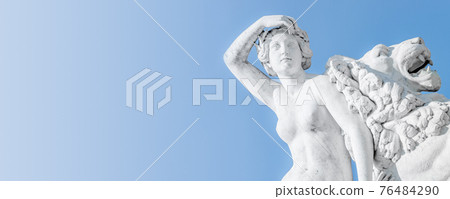 Banner of an ancient statue sensual Renaissance Era woman laying on big lion with blue sky gradient background in Potsdam, Germany, details, closeup 76484290