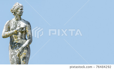 Ancient statue covered with moss and lichen of a sensual renaissance era woman in Potsdam, Germany 76484292