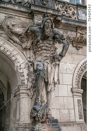 Very old statute of scary gatekeeper, medieval warrior with weapon in historical downtown of Dresden, Germany 76484543