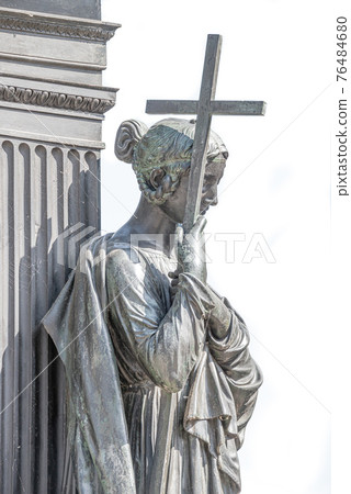 Old metal statue of a sensual woman as a prayer with a cross and Old metal statue of a sensual woman as a prayer with a cross and 76484680