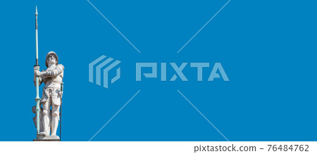 Banner with a very old statute heavy armed gatekeeper, a medieval warrior with spire in historical downtown of Dresden at blue sky and copy space, Germany. 76484762