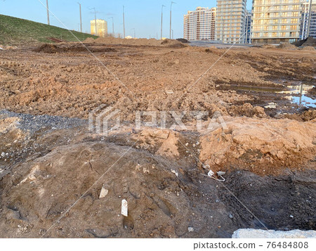 Construction industrial work on the road and brown dug earth with clay while paving asphalt Construction industrial work on the road and brown dug earth with clay while paving asphalt 76484808