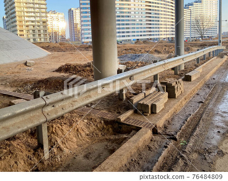 Construction industrial work under a bridge with columns and bumpers and a large car overpass road Construction industrial work under a bridge with columns and bumpers and a large car overpass road 76484809