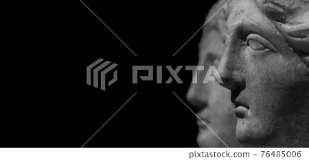 Marble ancient different heads as humankind in a isolated black background, streamer, banner with paste space 76485006