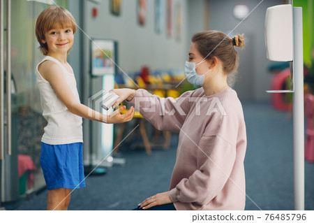 Child temperature measurement by laser thermometer at kindergarten. 76485796