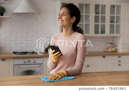 Housewife enjoy easy cleaning hold phone lost in good thoughts 76485963