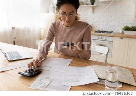 Millennial hispanic businesswoman do paperwork pay bills at home office Millennial hispanic businesswoman do paperwork pay bills at home office 76486302