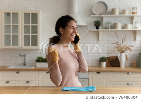 Excited housewife answer call listen great news of winning lottery Excited housewife answer call listen great news of winning lottery 76486304