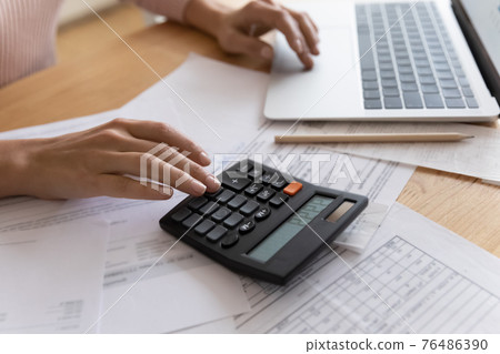 Close up cropped view of young woman doing financial paperwork 76486390