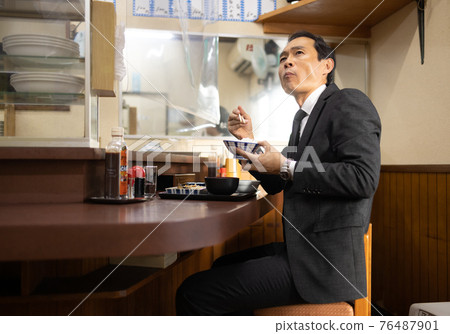 Office worker having lunch at a set meal shop Office worker having lunch at a set meal shop 76487901