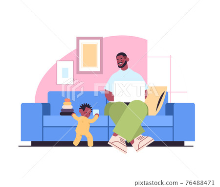 father playing with little son and using laptop fatherhood parenting concept dad spending time with his kid 76488471