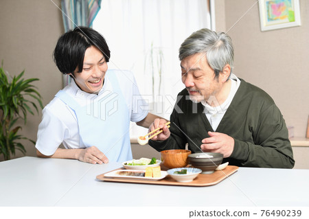 吃東西的老人和圍裙的男性看護者 76490239