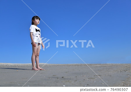 Scenery of a barefoot girl standing in the sandbox Scenery of a barefoot girl standing in the sandbox 76490307