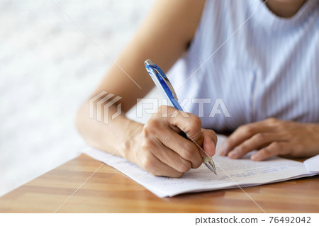 Close up hand of business women use pen writing document paper. Female hand close up writing with a blue pen on a white sheet. Woman writes information on a piece of paper. Close up hand of business women use pen writing document paper. Female hand close up writing with a blue pen on a white sheet. Woman writes information on a piece of paper. 76492042