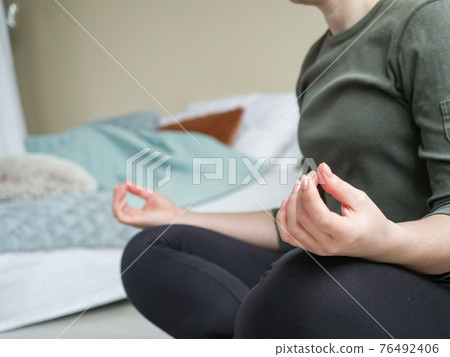 Woman sitting on floor in posture of meditation Woman sitting on floor in posture of meditation 76492406
