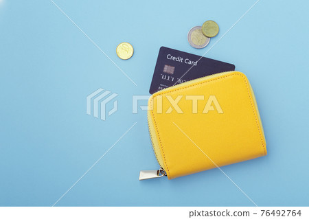 Credit card in wallet with coins on blue background Credit card in wallet with coins on blue background 76492764