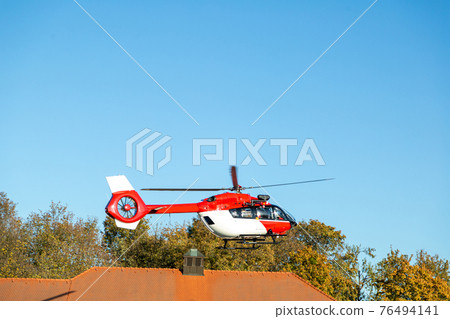 Fire fighter helicopter flying in the air over the city 76494141