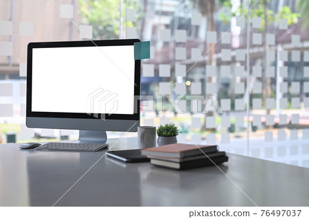 Modern office with computer, books, coffee cup and plant on white office desk. Modern office with computer, books, coffee cup and plant on white office desk. 76497037