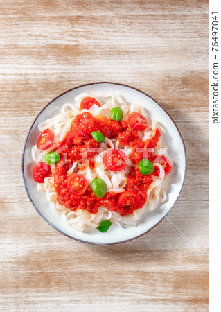 Konjac pasta with tomato sauce, shot from the top on a wooden background Konjac pasta with tomato sauce, shot from the top on a wooden background 76497041