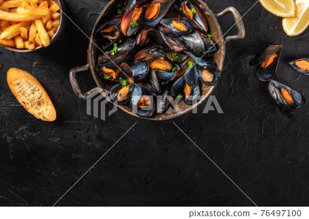 Mussels with a place for text, shot from above on a black background Mussels with a place for text, shot from above on a black background 76497100