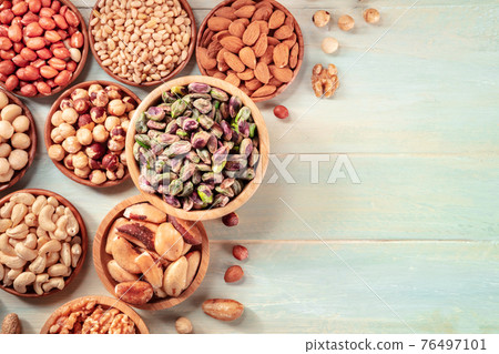 Nuts design layout with copy space. Pistachios, cashews, pine nuts etc Nuts design layout with copy space. Pistachios, cashews, pine nuts etc 76497101