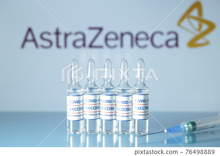 AstraZeneca vaccine against COVID-19. Glass medical vials with liquid on the background Astra Zeneca company logo. Ampoules with coronavirus vaccine on a medical glass table AstraZeneca vaccine against COVID-19. Glass medical vials with liquid on the background Astra Zeneca company logo. Ampoules with coronavirus vaccine on a medical glass table 76498889