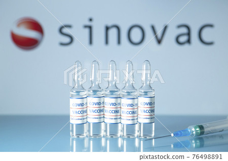 Sinovac vaccine against COVID-19. Glass medical vials with liquid on the background Sinovac company logo. Ampoules with coronavirus vaccine on a medical glass table Sinovac vaccine against COVID-19. Glass medical vials with liquid on the background Sinovac company logo. Ampoules with coronavirus vaccine on a medical glass table 76498891