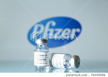 Pfizer vaccine against COVID-19. Glass medical vials with liquid on the background Pfizer company logo. Ampoules with coronavirus vaccine on a medical glass table Pfizer vaccine against COVID-19. Glass medical vials with liquid on the background Pfizer company logo. Ampoules with coronavirus vaccine on a medical glass table 76498906