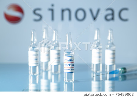 Sinovac vaccine against COVID-19. Glass medical vials with liquid on the background Sinovac company logo. Ampoules with coronavirus vaccine on a medical glass table Sinovac vaccine against COVID-19. Glass medical vials with liquid on the background Sinovac company logo. Ampoules with coronavirus vaccine on a medical glass table 76499008