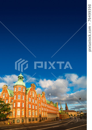 Old stock exchange building illuminated by sunrise in early morning, Copenhagen, Denmark, summer time, paste space Old stock exchange building illuminated by sunrise in early morning, Copenhagen, Denmark, summer time, paste space 76499398