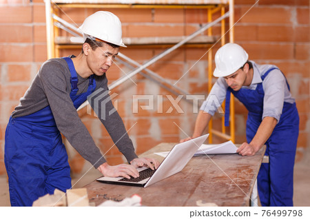 Professional builders using laptop Professional builders using laptop 76499798
