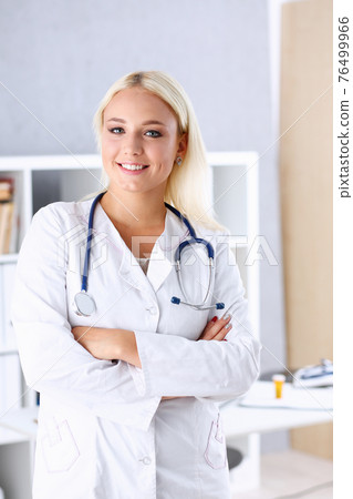 Beautiful smiling female doctor stand in office portrait 76499966