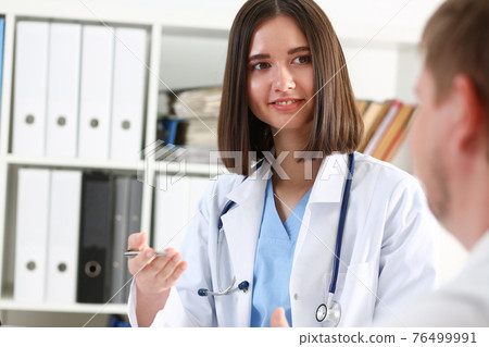 Female doctor hand hold silver pen and showing pad Female doctor hand hold silver pen and showing pad 76499991