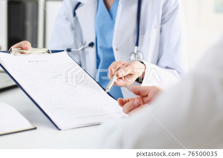 Female doctor hand hold silver pen and showing pad Female doctor hand hold silver pen and showing pad 76500035