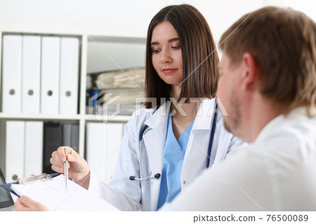 Female doctor hand hold silver pen and showing pad 76500089