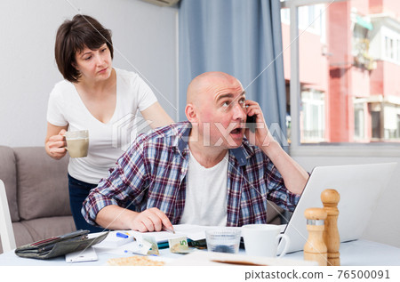Wife calms husband who is upset about financial results. 76500091