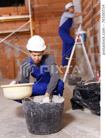 Two builders in process of finishing work Two builders in process of finishing work 76500554