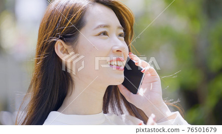 年輕女子在戶外打電話 年輕女子在戶外打電話 76501679