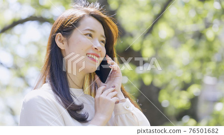 年輕女子在戶外打電話 年輕女子在戶外打電話 76501682